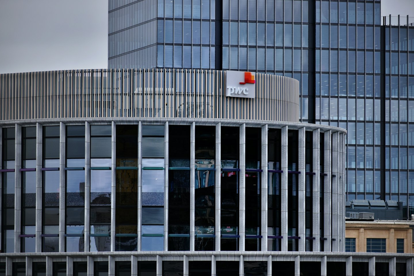 Budynek korporacyjny PWC z metalowymi płetwami i szklanymi oknami.
